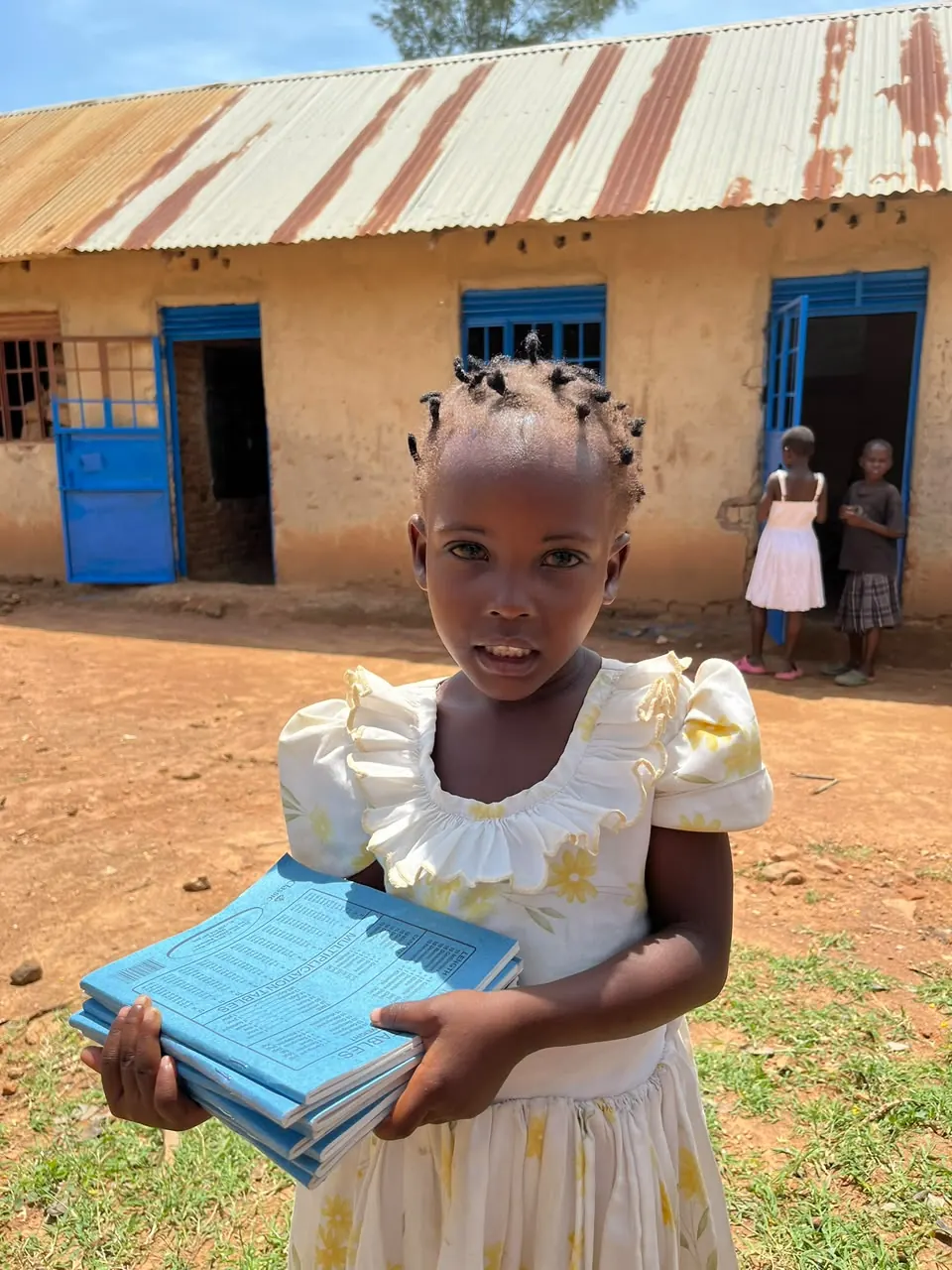 Child receiving exercise books in Bumbo village